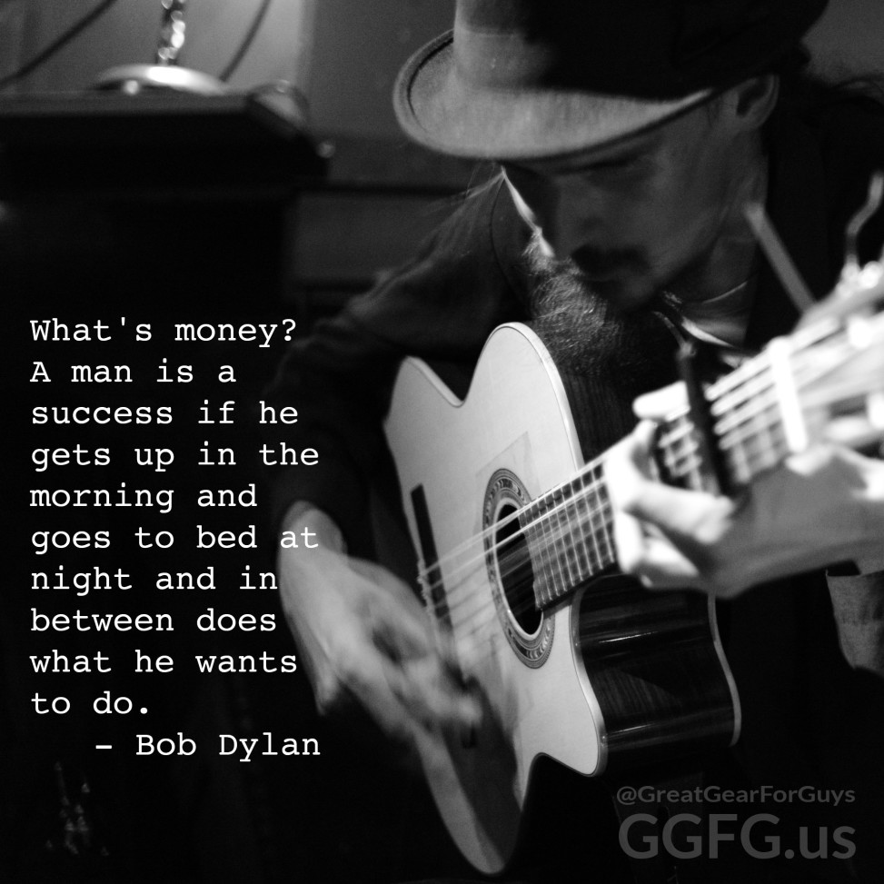 A man in a hat playing a guitar.