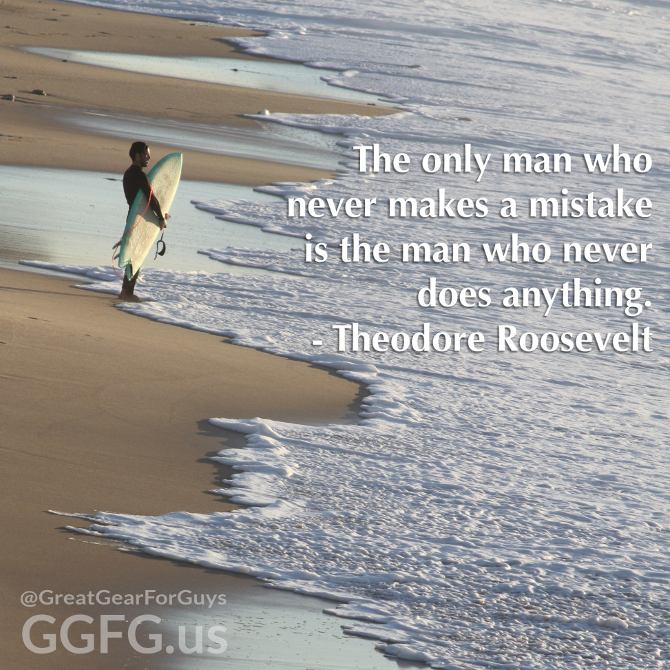 Photo of a surfer on the beach looking out over the ocean.